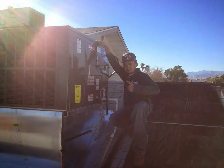 HVAC technician performing AC Tune-Up on a rooftop unit in Sacramento